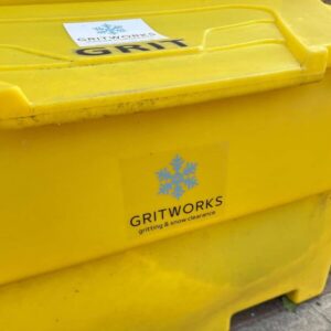 Yellow Grit bin on a street with a Gritworks logo on